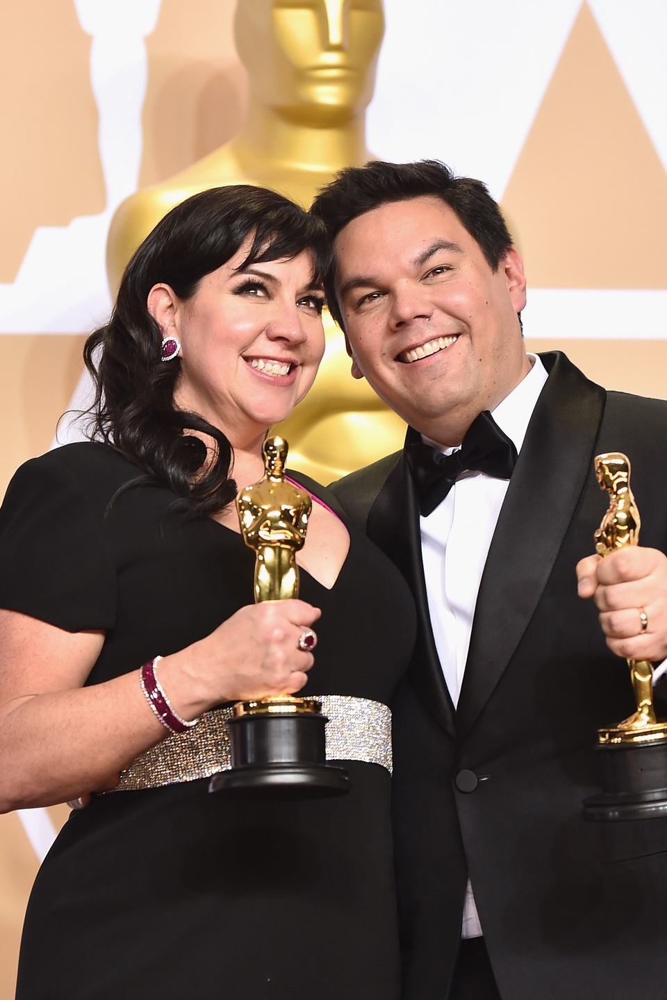 Composers Kristen Anderson-Lopez (L) and Robert Lopez, winners of the Best Original Song award for 'Remember Me' from 'Coco,' pose in the press room during the 90th Annual Academy Awards at Hollywood & Highland Center on March 4, 2018 in Hollywood, California. (Photo by Alberto E. Rodriguez/Getty Images)